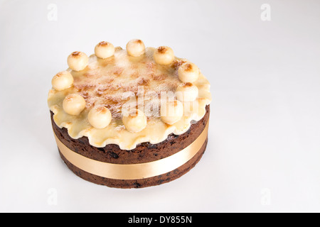 Simnel cake sur un fond clair avec un ruban jaune massepain cannelés avec 11 boules de massepain 'Couper' co(24d) 35 Banque D'Images