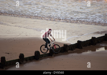 Adolescent en vélo sur la plage Banque D'Images