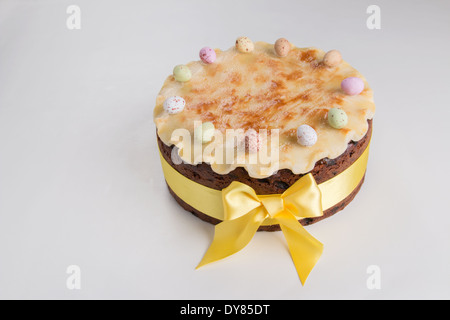 Simnel cake sur un fond clair avec un ruban jaune massepain cannelé avec un arc avec 11 oeufs colorés, (32 de 35) Banque D'Images