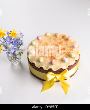 Simnel cake sur un fond clair avec un ruban jaune massepain cannelé avec un arc avec 11 oeufs colorés,(34 sur 35) Banque D'Images