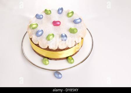 Simnel gâteau décoré avec du massepain et feuilles chocolat oeufs sur une plaque blanche avec fond blanc (19 0F 35) Banque D'Images