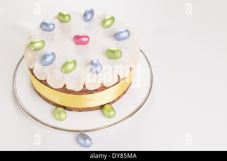 Simnel gâteau décoré avec du massepain et feuilles chocolat oeufs sur une plaque blanche avec fond blanc ( 20 sur 35) Banque D'Images