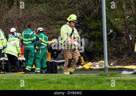 Queenswood dur, Leeds West Yorkshire UK 9 avril 2014. Les services d'urgence assister à un incident survenu à autour de 14 heures dans lequel un véhicule s'est retourné dans une longue rue de banlieue. Deux personnes ont été coupées à l'abri de la voiture qui s'est retrouvée sur son toit dans un bois au bord de la route dans le parc Becketts zone LS6 et retiré de la scène en ambulance. Le West Yorkshire Air Ambulance a également assisté à la scène mais n'a pas été utilisée pour le transport des blessés. Un autre véhicule, une Seat Ibiza jaune, qui a été vu pour être endommagé a également été stationnée à proximité. Crédit : Ian Wray/Alamy Live News Banque D'Images