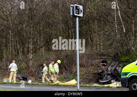 Queenswood dur, Leeds West Yorkshire UK 9 avril 2014. Les services d'urgence assister à un incident survenu à autour de 14 heures dans lequel un véhicule s'est retourné dans une longue rue de banlieue. Deux personnes ont été coupées à l'abri de la voiture qui s'est retrouvée sur son toit dans un bois au bord de la route dans le parc Becketts zone LS6 et retiré de la scène en ambulance. Le West Yorkshire Air Ambulance a également assisté à la scène mais n'a pas été utilisée pour le transport des blessés. Un autre véhicule, une Seat Ibiza jaune, qui a été vu pour être endommagé a également été stationnée à proximité. Crédit : Ian Wray/Alamy Live News Banque D'Images