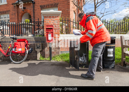 Royal Mail postman post collecte prêts pour la livraison sur son vélo dans le village de Plumtree, Lancashire, England, UK Banque D'Images
