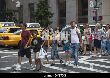 Famille shopping à Manhattan contre la 5e Avenue à la 57e Rue, New York. Banque D'Images