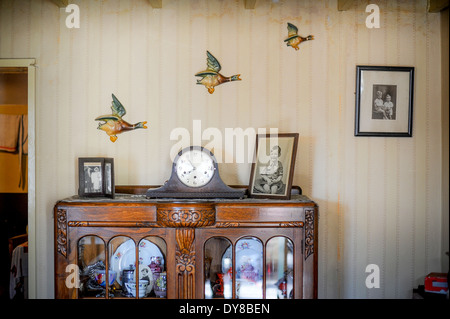 Flying ducks sur papier peint à l'ancienne dans une seconde guerre mondiale, la salle de séjour. Ancien bahut, réveil et photographies Banque D'Images