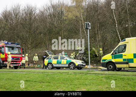 Queenswood dur, Leeds West Yorkshire UK 9 avril 2014. Les services d'urgence assister à un incident survenu à autour de 14 heures dans lequel un véhicule s'est retourné dans une longue rue de banlieue. Deux personnes ont été coupées à l'abri de la voiture qui s'est retrouvée sur son toit dans un bois au bord de la route dans le parc Becketts zone LS6 et retiré de la scène en ambulance. Le West Yorkshire Air Ambulance a également assisté à la scène mais n'a pas été utilisée pour le transport des blessés. Un autre véhicule, une Seat Ibiza jaune, qui a été vu pour être endommagé a également été stationnée à proximité. Crédit : Ian Wray/Alamy Live News Banque D'Images