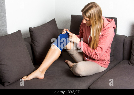 La jeune femme a été blessé au genou, bandage et le refroidissement. Banque D'Images