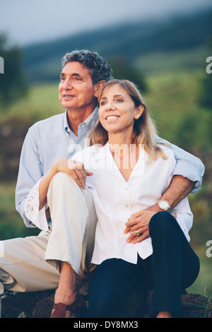 L'amour heureux couple d'âge moyen se détendre en admirant le coucher du soleil Banque D'Images