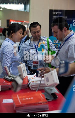 Shenzhen, la province chinoise du Guangdong. 10 avr, 2014. L'expérience des visiteurs étrangers les appareils médicaux portables lors de la 2e Expo de la technologie de l'information la Chine à Shenzhen, province du Guangdong en Chine du sud, le 10 avril 2014. L'Expo se déroulera du 10 au 12 avril. © AAM Siqian/Xinhua/Alamy Live News Banque D'Images