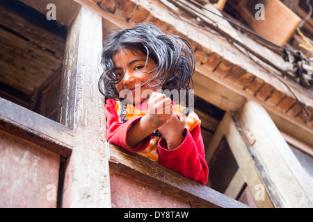 Jeune fille Napali dans une fenêtre à Bhaktapur, Népal Banque D'Images