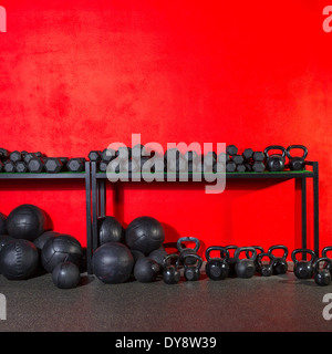 Kettlebells haltères et slam pondérée de l'équipement de formation de poids balles de gymnastique au mur rouge Banque D'Images