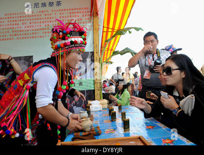 Le Xishuangbanna, la province chinoise du Yunnan. 10 avr, 2014. Une fille de l'ethnie Hani sert le thé pour les touristes pendant la 6e thé Menghai Menghai comté King Carnaval dans la préfecture autonome Dai de Xishuangbanna, au sud-ouest de la province chinoise du Yunnan, le 10 avril 2014. © Lin Yiguang/Xinhua/Alamy Live News Banque D'Images