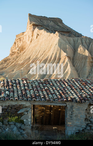 Falaises érodées par les précipitations juxtaposées à l'abri traditionnel de bétail ruiné sur la zone d'argile seulement du parc naturel de Bardenas Reales de Navarra, Navarre, Espagne Banque D'Images