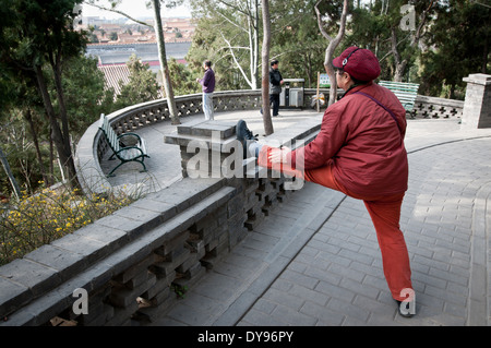 Vieille femme chinoise de faire des exercices du matin au parc Jingshan, Beijing, Chine Banque D'Images