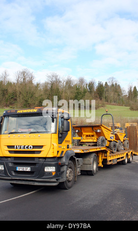 Un chargeur bas articulés transportant des camions à benne le long de la route A23 à Coulsdon, Surrey, Angleterre Banque D'Images