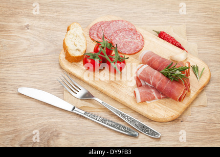 Prosciutto, salami, pain, légumes et épices. Sur fond de table en bois Banque D'Images