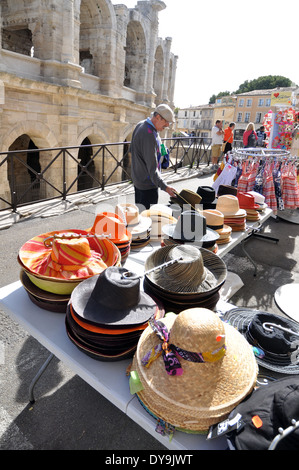 Homme regarde hats sur en face de la stalle de spruced sablé pierre arches de l'Amphithéâtre Romain à Arles France Banque D'Images