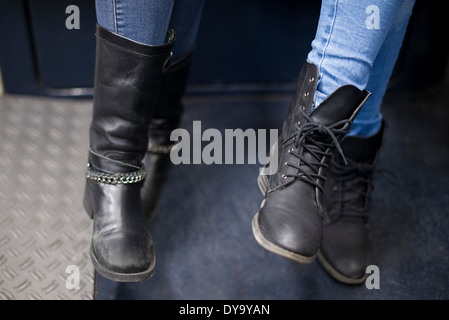 Les femmes siégeant ensemble on Subway train, close-up de bottes Banque D'Images