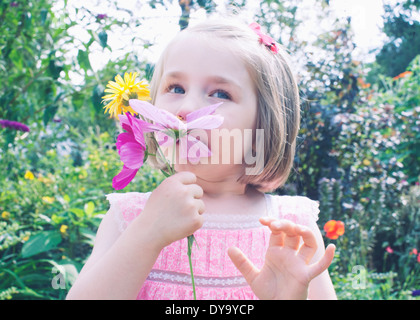 Little girl smelling flower Banque D'Images