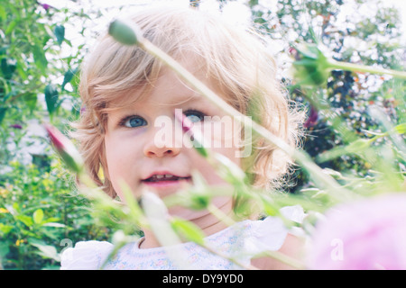 Petite fille en fleur jardin, portrait Banque D'Images