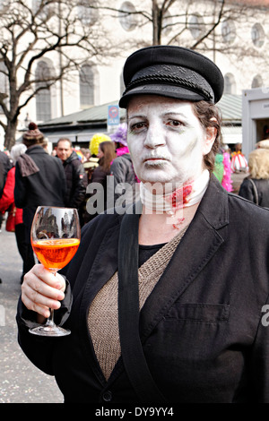 Victime de Vampire tenant un verre coloré, Fasching street party, Munich, Haute-Bavière, Allemagne, Europe Banque D'Images