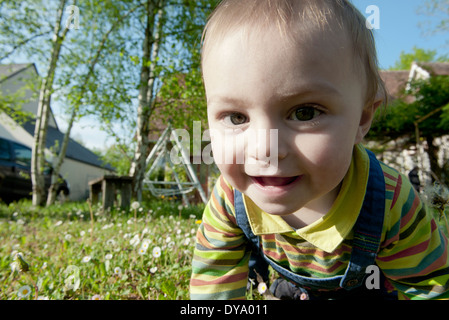 Baby crawling in grass, smiling, portrait Banque D'Images