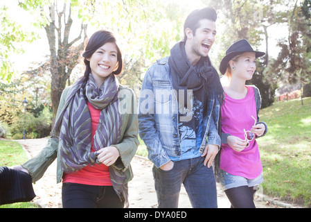 Friends walking together in park Banque D'Images