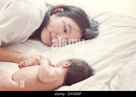 Mother with baby on bed, portrait Banque D'Images