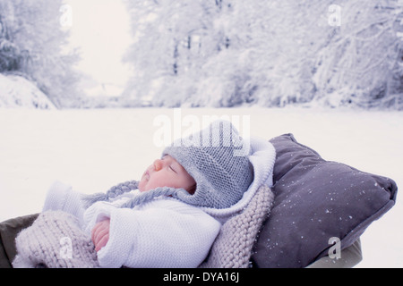 Baby sleeping in bassinet en scane hiver Banque D'Images