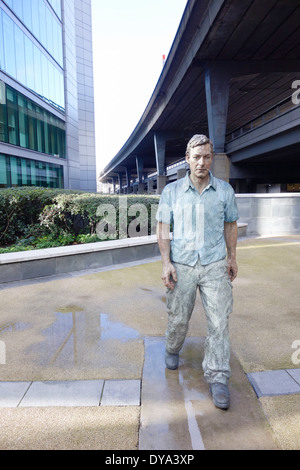 London, Paddington Basin. 'Walking man', peint statue en bronze par le sculpteur, Sean Henry Banque D'Images