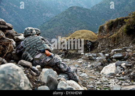 Les soldats de l'Armée US avec l'Équipe de reconstruction provinciale de Kunar, prendre le couvercle au cours d'une embuscade tendue par des insurgés talibans après la tenue d'une shura, ou d'une réunion le 7 décembre 2009 dans le district de Shigal Lachey, village, dans la province de Kunar, Afghanistan. Banque D'Images