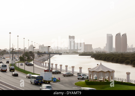 Trafic sur Al Salam Street, à côté de la mangrove avec Al Bahar Towers et la ville d'Abu Dhabi dans l'arrière-plan. Banque D'Images