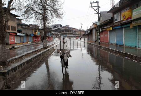 Srinagar, au Cachemire sous contrôle indien. Apr 12, 2014. Un homme Cachemire chevauche son vélo dans un marché fermé pendant une grève à Srinagar, la capitale d'été du Cachemire sous contrôle indien, le 12 avril 2014. Appel à la grève par alliance séparatiste a frappé samedi la vie normale dans les zones à majorité musulmane du Cachemire sous contrôle indien y compris la région de la capitale d'été, à Srinagar. © Javed Dar/Xinhua/Alamy Live News Banque D'Images