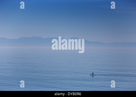 Deux stand up paddle boarders dans False Bay à Cape Town avec les montagnes Hottentots Holland dans l'arrière-plan Banque D'Images