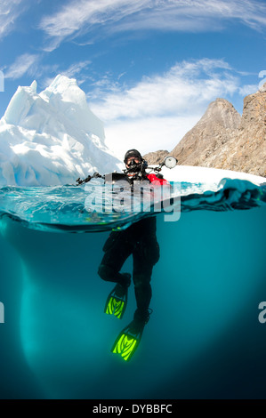 Diver en face d'un iceberg, Astrolabe Island, Péninsule Antarctique, l'Antarctique. Banque D'Images