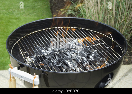 La combustion du charbon et de se préparer pour l'été BBQ Banque D'Images