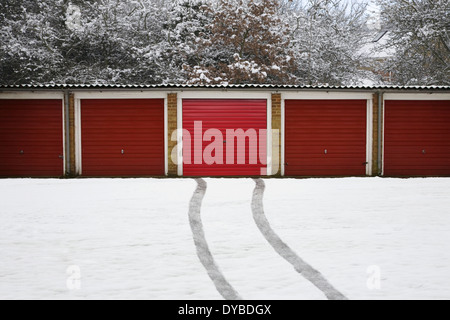 Rangée de garages rouge véhicule avec les traces de pneus dans la neige, d'un garage, centre Banque D'Images