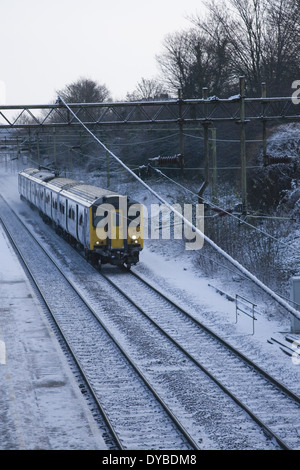 National Express East Anglia un train de passagers fait son chemin à travers une banlieue couverte de neige dans l'Essex, Angleterre du Sud-Est, Banque D'Images