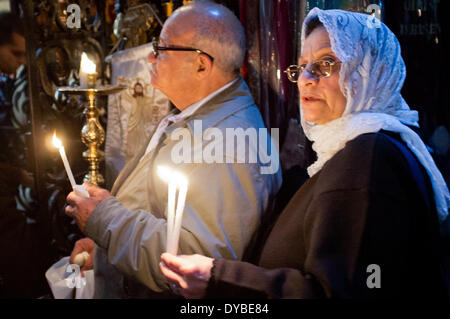 Jérusalem, au Moyen-Orient. 13 avr, 2014. Les chrétiens orthodoxes de l'est qu'ils tiennent des bougies prendre part à la prière et processions dans l'église du Saint Sépulcre le Dimanche des Rameaux. Banque D'Images