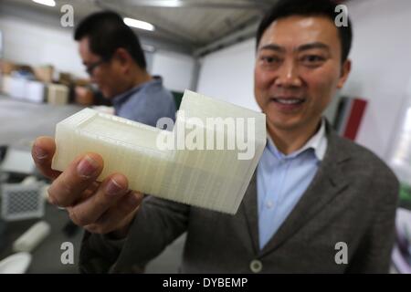 Shanghai, Chine. Apr 12, 2014. L'inventeur de la 3D-imprimé Ma maison Yihe (L) illustre un modèle d'une impression 3D-house à Shanghai, la Chine orientale, le 12 avril 2014. Dix maisons ont été construites de déchets de construction à l'aide d'une technologie d'impression 3D en 24 heures à Shanghai. Credit : Pei Xin/Xinhua/Alamy Live News Banque D'Images