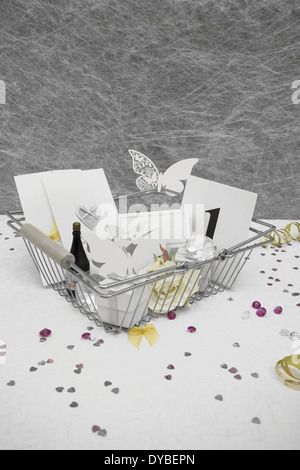 Faveurs de mariage dans un panier sur une nappe blanche avec des rubans,bows,coeur confettis et petites décorations de table diamant Banque D'Images