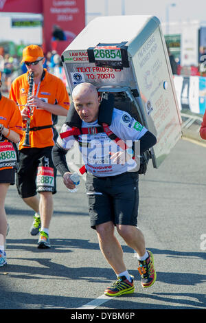 Londres, Royaume-Uni. 13 avr, 2014. Homme avec un réfrigérateur. Il vise à compléter quatre marathons en un jour avec une 42kg (Smeg) 6.6St fixé à son retour. Le Marathon de Londres commence à Greenwich à Blackheath passe par Canary Wharf et termine dans le Mall. Londres, Royaume-Uni, 13 avril 2014. Guy Bell, 07771 gbphotos@guy 786236. Banque D'Images