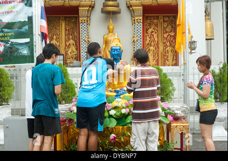 Bangkok, Thaïlande - personnes verser de l'eau plus de statue de Bouddha au cours des célébrations du nouvel an thaïlandais Songkran Banque D'Images