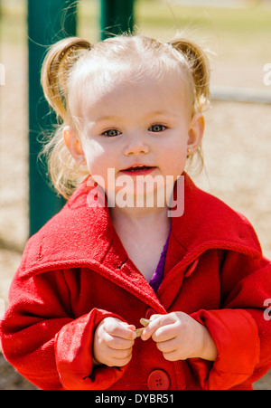 Mignon, adorable petite fille de 16 mois à l'affiche sur un parc jeux pour enfants Banque D'Images