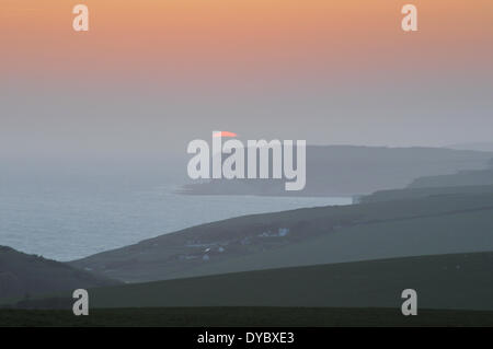 Beachy Head, East Sussex, UK..13 Avril 2014..Le soleil se glisse derrière cloud comme sea mist enveloppes la côte du Sussex. Prises de Beachy Head, vers sept Sœurs falaises et Urrugne.David Burr/Alamy Live News Banque D'Images