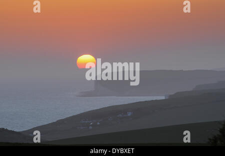 Beachy Head, East Sussex, UK..13 Avril 2014..Le soleil se glisse derrière cloud comme sea mist enveloppes la côte du Sussex. Prises de Beachy Head, vers sept Sœurs falaises et Urrugne.David Burr/Alamy Live News Banque D'Images