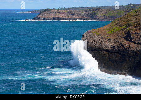 De puissantes vagues dans l'océan Pacifique s'écrasant sur la rive nord de Kauai.Des couches de lave volcanique et de rochers de tuf peuvent être vues dans les falaises. Banque D'Images