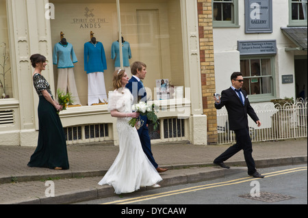 Bride & Groom marcher en procession tout en étant filmé par Hay-on-Wye, Powys, Wales, UK Banque D'Images